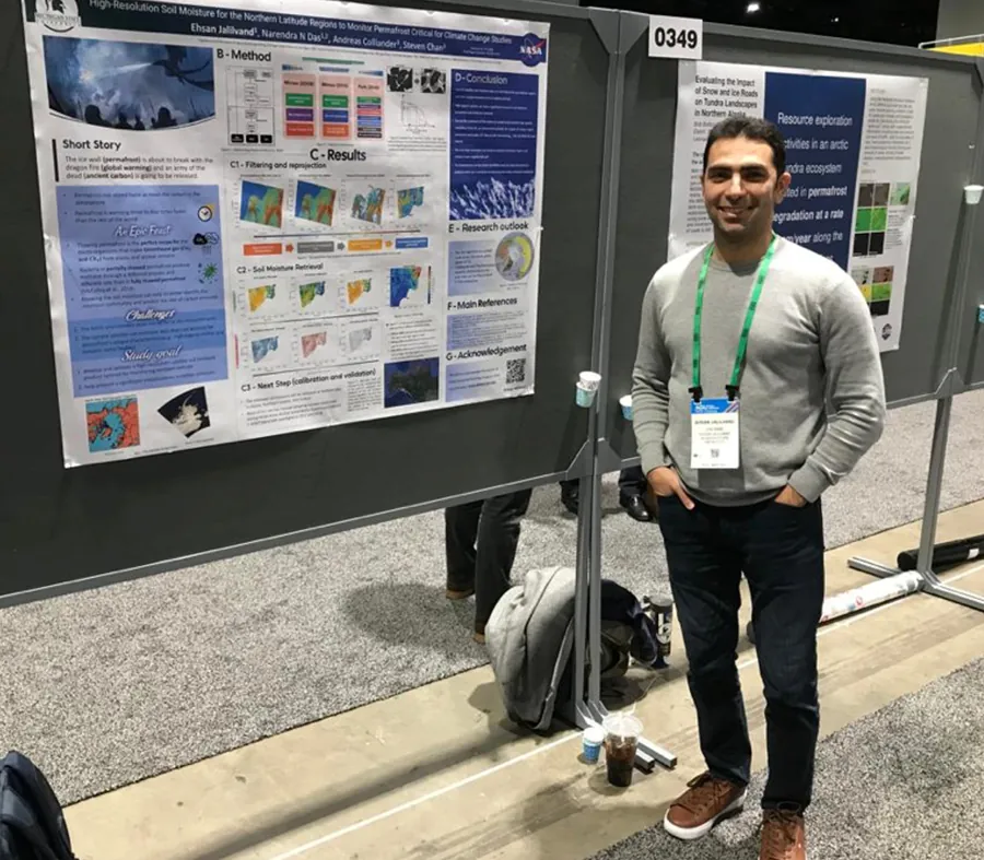 Ehsan Jalilvand smiling beside his AGU 2022 poster on high-resolution soil moisture for monitoring permafrost, with a dragon breathing fire at an ice wall in its top corner.